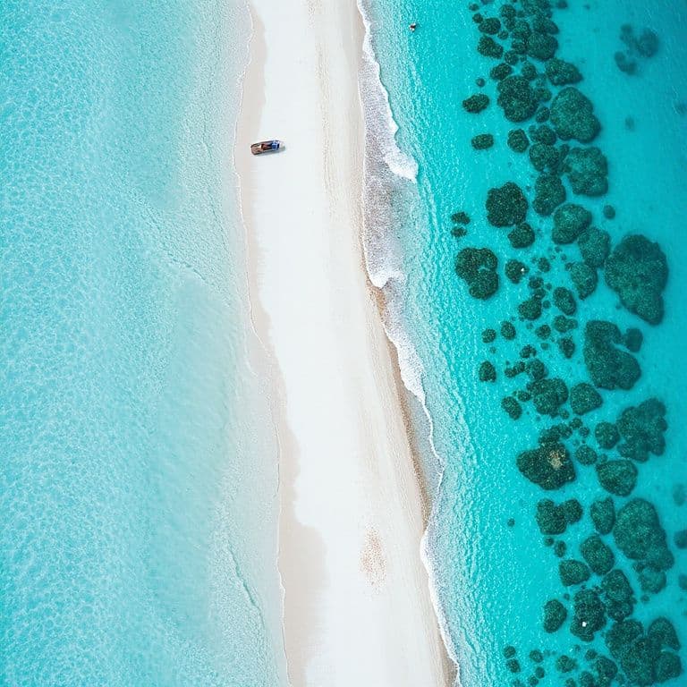 Aerial view of a tropical beach with turquoise water and white sand